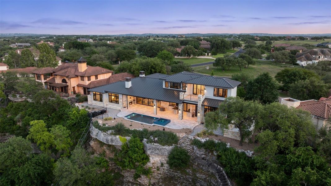 Contemporary residence featuring a dark-pitched roof and light-toned exterior