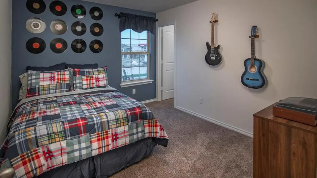 Bedroom featuring dark carpet and baseboards