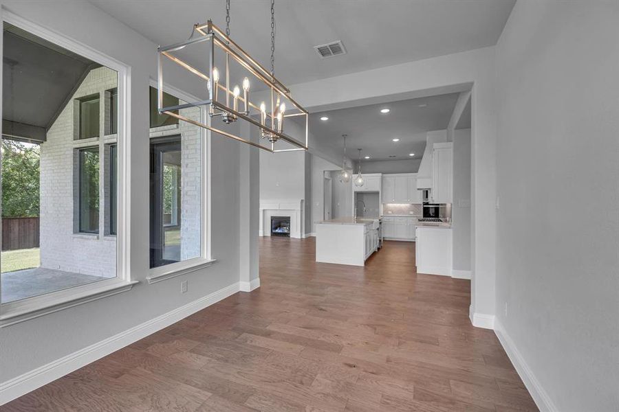 Unfurnished dining area featuring sink, wood-type flooring, and a chandelier