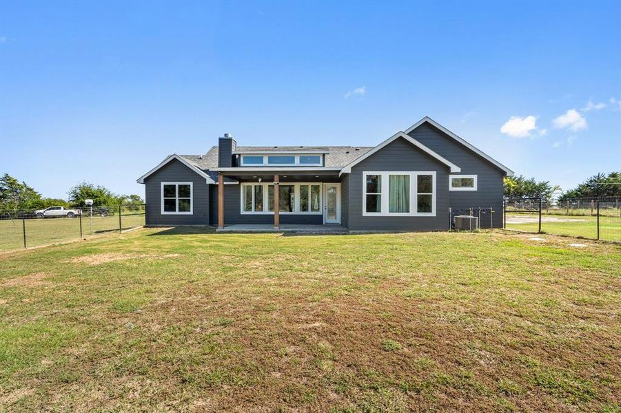 Back of property with a patio, central AC unit, and a yard