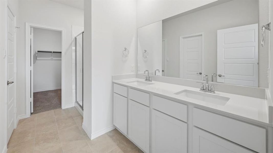 Contemporary bathroom featuring a dual vanity with white cabinetry, light-toned countertops, and chrome fixtures Contemporary bathroom featuring a dual vanity with white cabinetry, light-toned countertops, and chrome fixtures