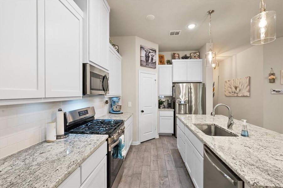 Gas cooktop, granite countertops with stainless steel appliances