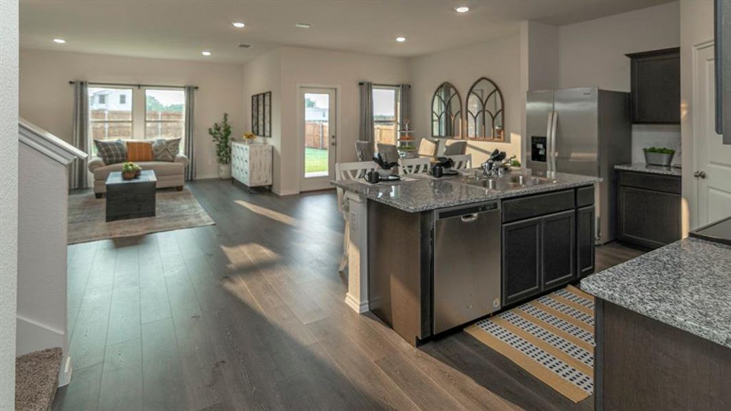 Open-concept living space featuring wood-finish flooring, recessed lighting, and ample natural light