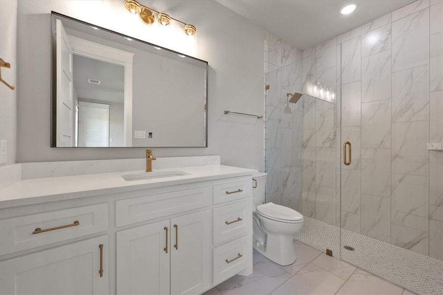 Bathroom with vanity, toilet, and a shower with door