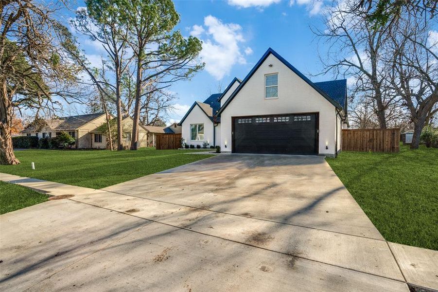 Modern farmhouse style home featuring a garage and a front lawn