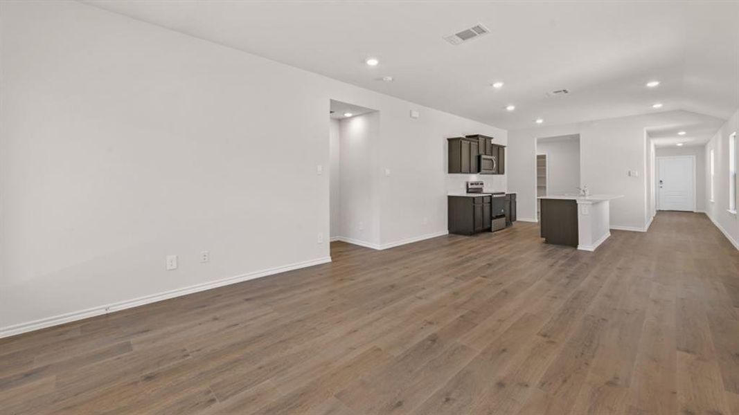 Open-concept living area featuring wood-finish flooring, recessed lighting, and a white interior color palette