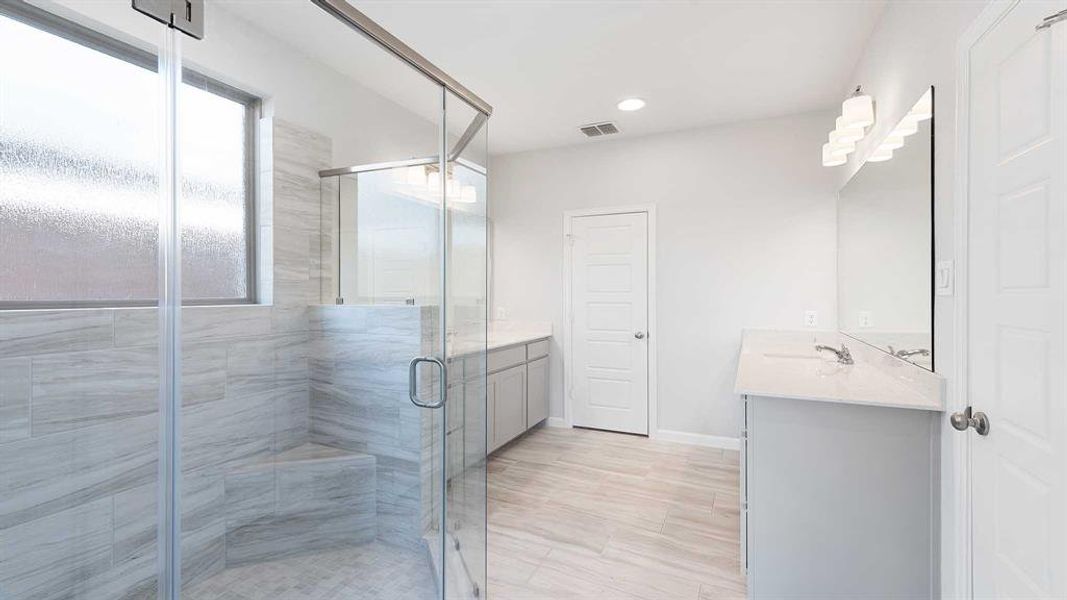 Bathroom featuring vanity and a shower with door