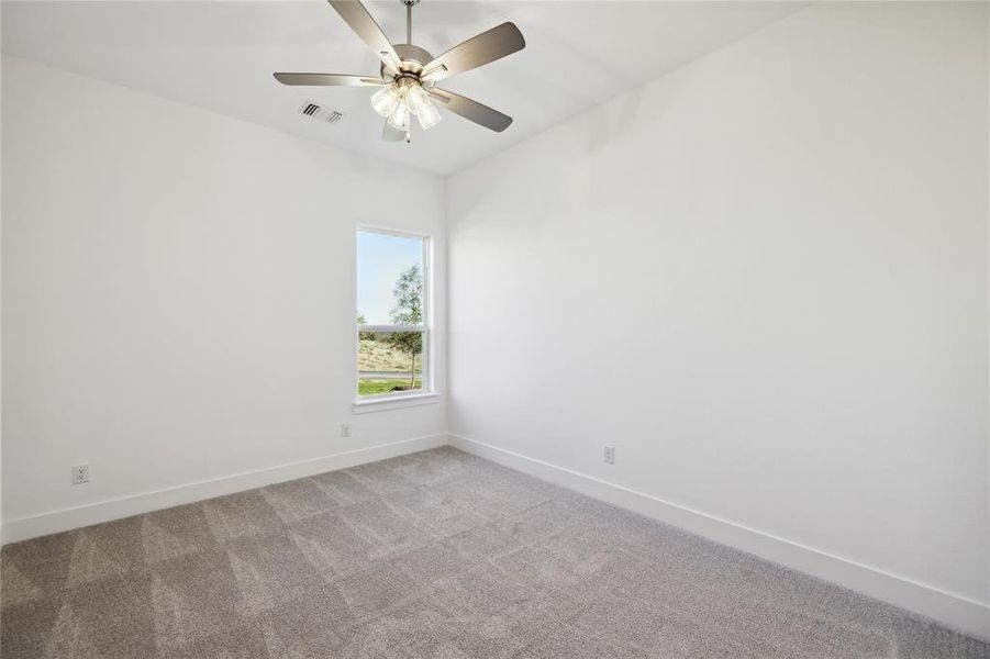 Unfurnished room featuring light colored carpet and ceiling fan