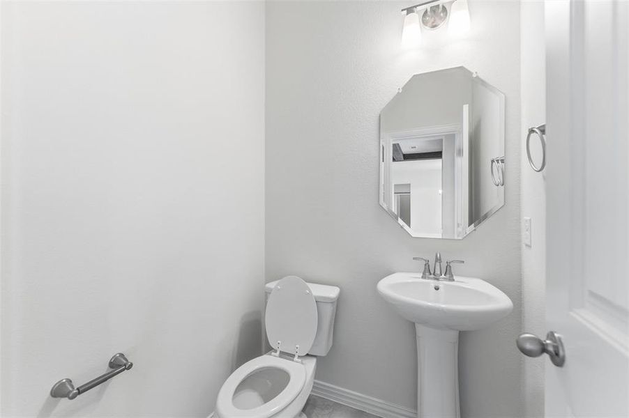 Half bath with toilet and baseboards