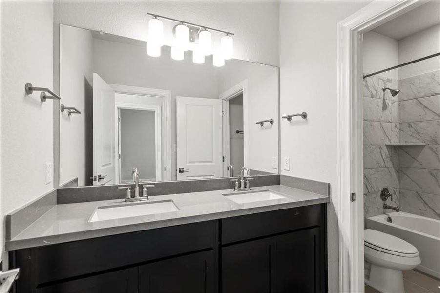 Full bathroom featuring double vanity and bathing tub / shower combination