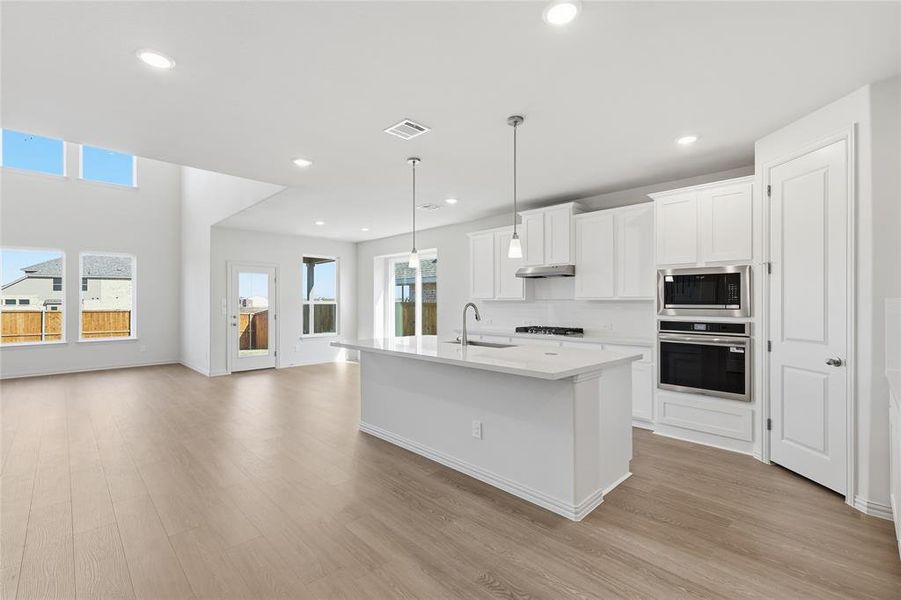 Kitchen with pendant lighting, white cabinets, stainless steel appliances, light wood-style floors, and recessed lighting Kitchen with pendant lighting, white cabinets, stainless steel appliances, light wood-style floors, and recessed lighting