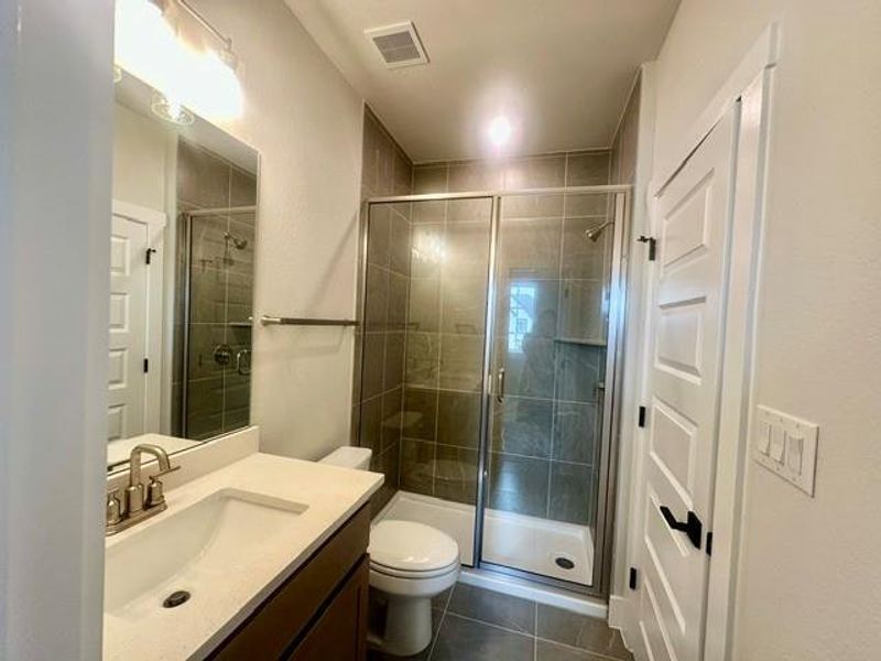 Modern bathroom featuring sleek vanity with ample counter space and a glass-enclosed shower. Modern bathroom featuring sleek vanity with ample counter space and a glass-enclosed shower.