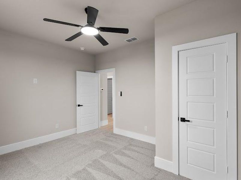 Unfurnished bedroom featuring light carpet and ceiling fan