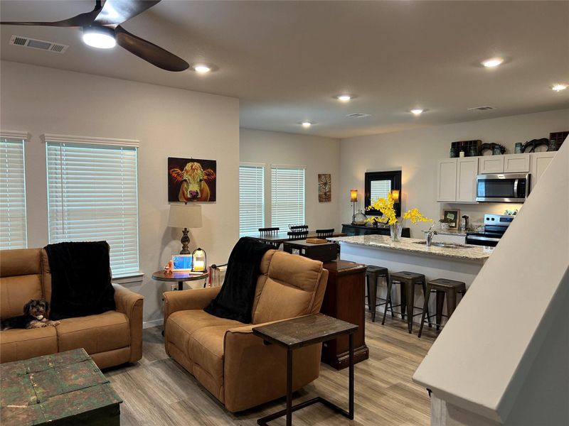 Open-concept living space featuring wood-finish flooring, recessed lighting, and a ceiling fan