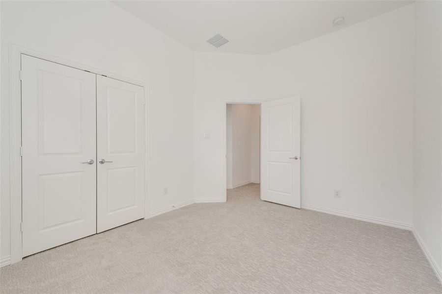 Unfurnished bedroom with a closet and light colored carpet