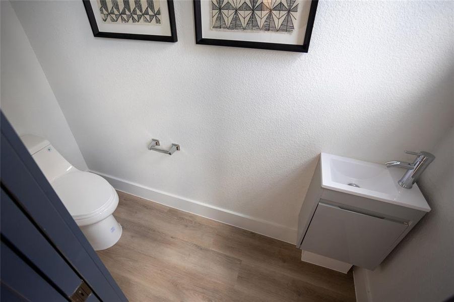 Bathroom featuring vanity, toilet, and wood-type flooring