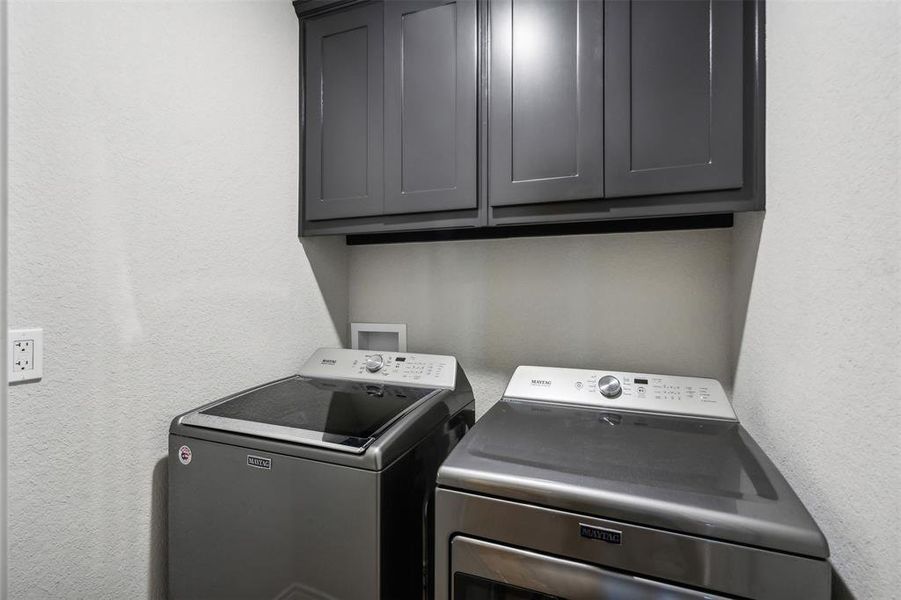 Laundry room with washer and dryer and cabinets