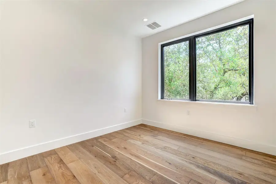 Spare room featuring baseboards and light wood finished floors