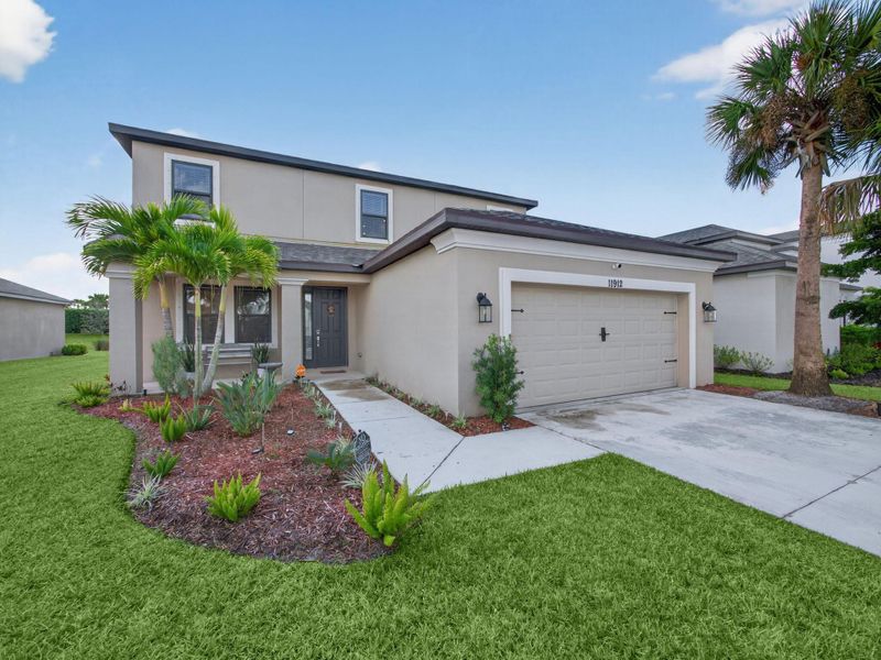 Front exterior of a new home in , Port St. Lucie, FL, highlighting curb appeal (Image 1).