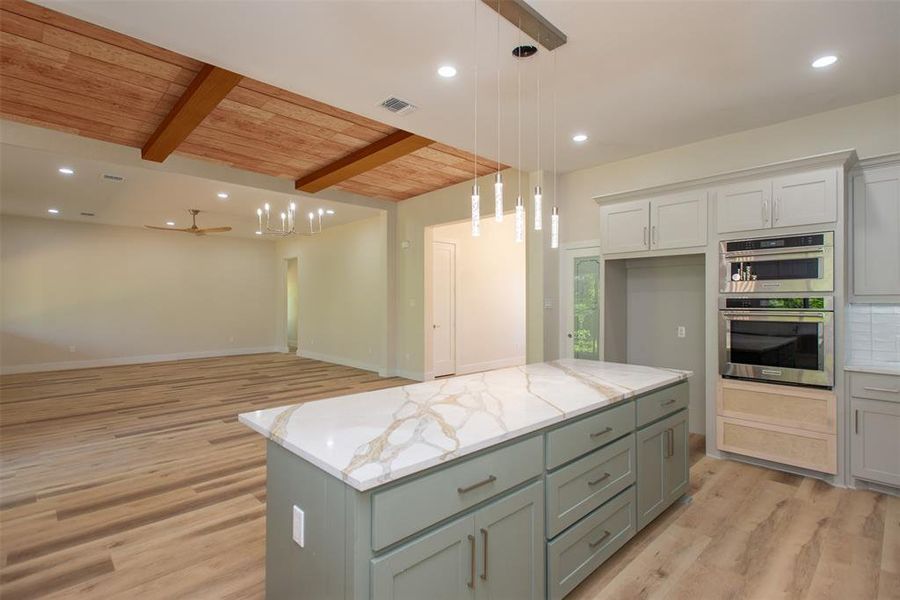 Kitchen featuring wooden ceiling, beamed ceiling, a center island, and light hardwood / wood-style floors