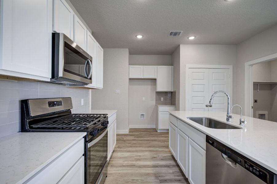 A kitchen with white cabinets.