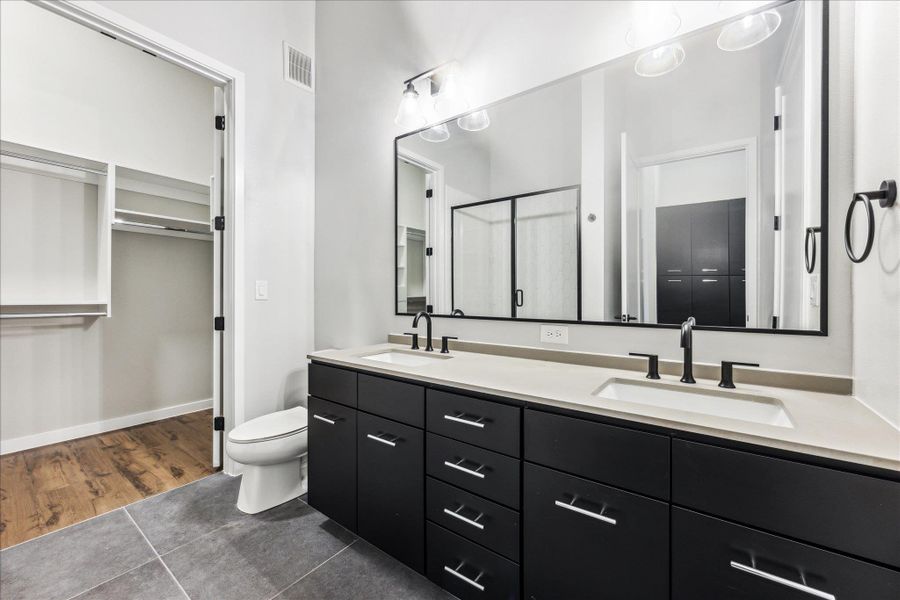 A well-appointed primary bathroom features a dual vanity with ample storage and a sleek, contemporary design. A well-appointed primary bathroom features a dual vanity with ample storage and a sleek, contemporary design.