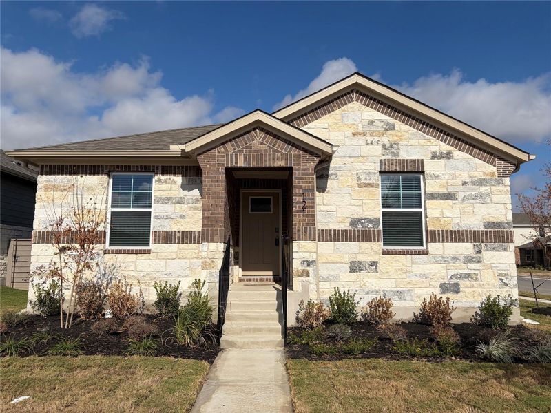 View of front of house with stone siding and a shingled roof