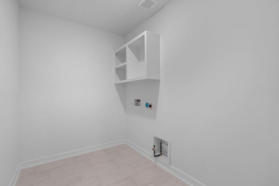 The laundry room layout is carefully planned for optimal workflow with designated areas for washing, drying, and storing.