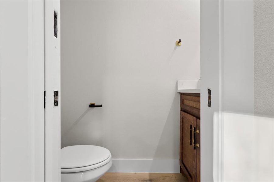 Bathroom featuring vanity, toilet, and wood-type flooring