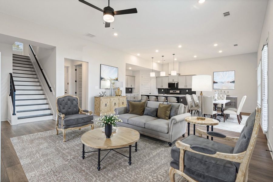 Open-concept living area with wood-finish flooring, a contemporary ceiling fan, and recessed lighting Open-concept living area with wood-finish flooring, a contemporary ceiling fan, and recessed lighting