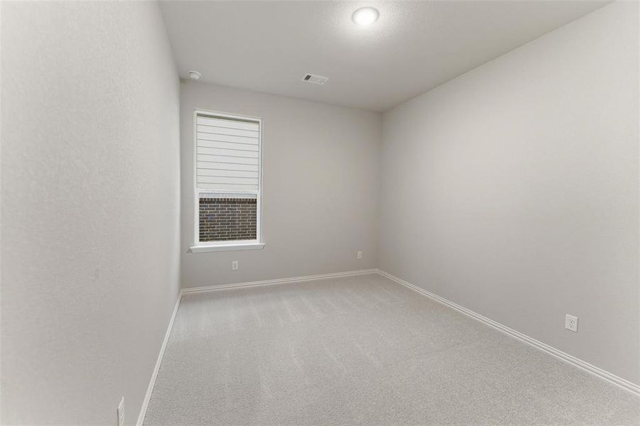 Carpeted room with neutral wall tones and a single window featuring horizontal blinds Carpeted room with neutral wall tones and a single window featuring horizontal blinds