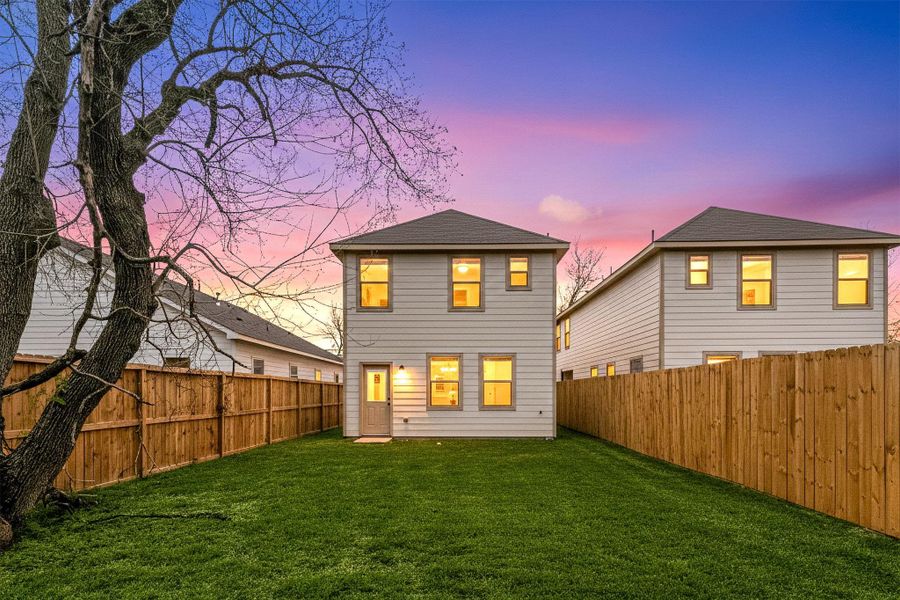 Private fenced backyard featuring a level grassy area, perfect for outdoor gatherings, pets, or play. Spacious yard with room to customize and enjoy outdoor living.