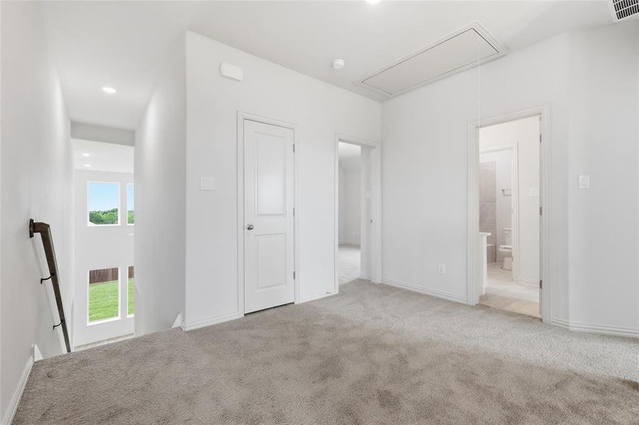 Open upstairs landing featuring neutral-toned carpeting, white walls, and bright recessed lighting