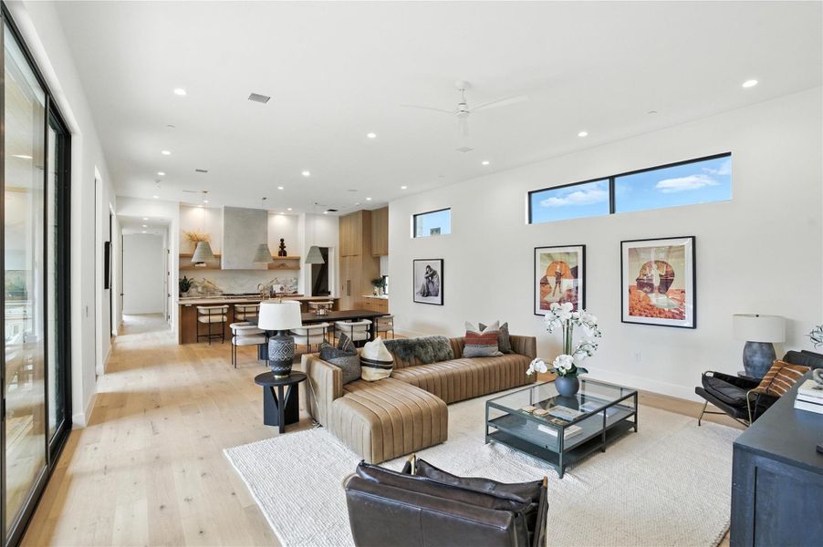 Living area featuring light wood finished floors, recessed lighting, and a ceiling fan Living area featuring light wood finished floors, recessed lighting, and a ceiling fan