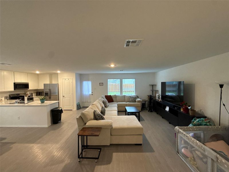 Open concept living space featuring wood-finish flooring, recessed lighting, and white walls