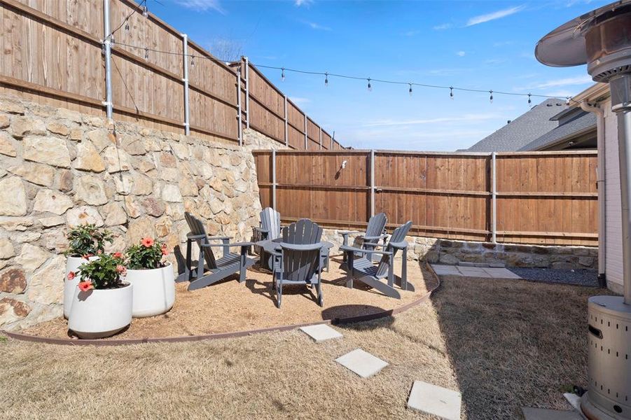 View of yard featuring a patio, fireplace, and hanging lights