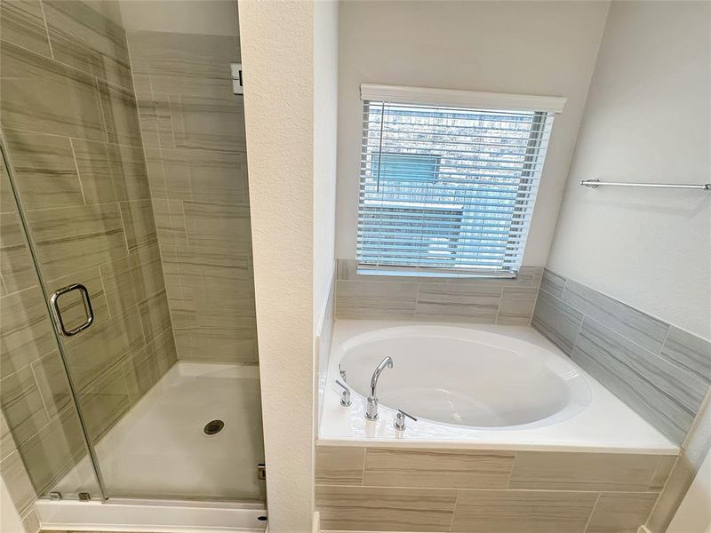 Modern master bathroom interior features a glass shower enclosure and a beautiful tub .