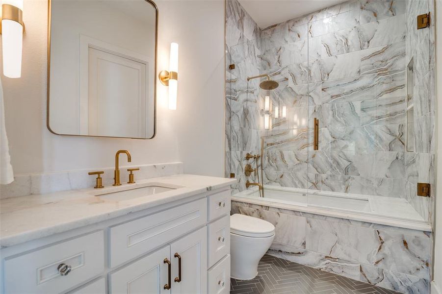 Full bathroom featuring tile patterned flooring, tiled shower / bath combo, toilet, and vanity