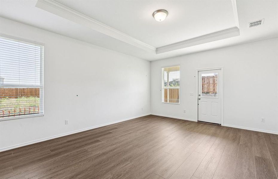 Spacious gathering room with large windows and tray ceiling *real home pictured Spacious gathering room with large windows and tray ceiling *real home pictured