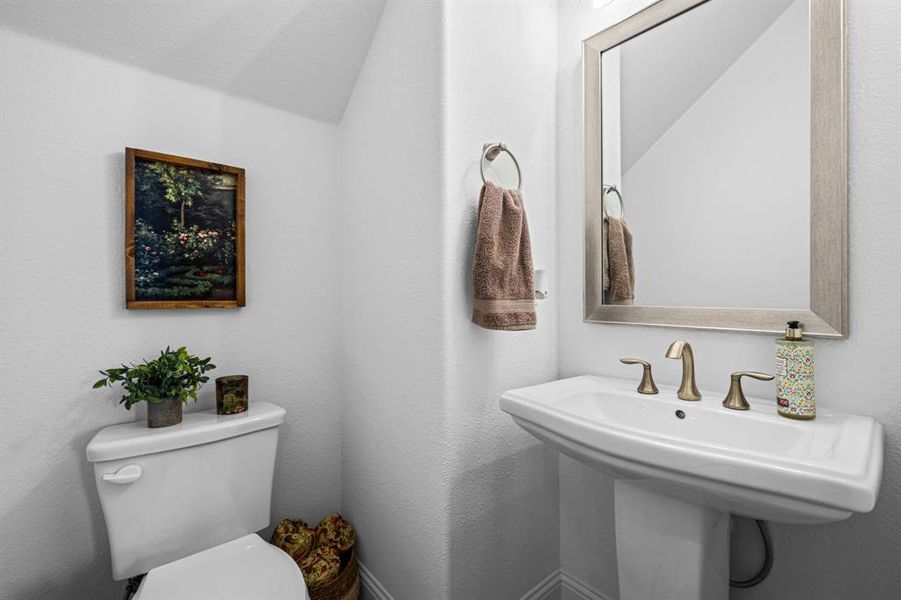 Half bathroom tucked under the stairs for guests. Half bathroom tucked under the stairs for guests.