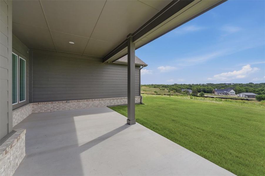 Covered concrete patio featuring recessed lighting, a stone veneer base, and durable siding Covered concrete patio featuring recessed lighting, a stone veneer base, and durable siding