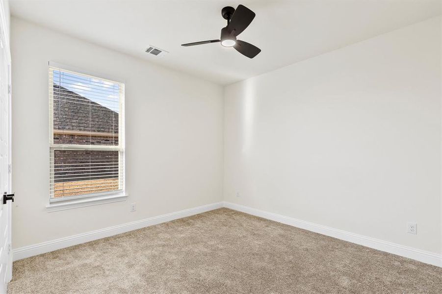 Carpeted spare room with plenty of natural light, visible vents, and baseboards Carpeted spare room with plenty of natural light, visible vents, and baseboards