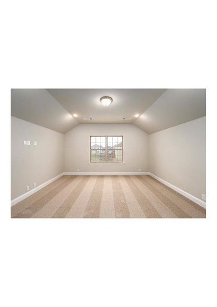 Bonus room featuring light carpet and vaulted ceiling