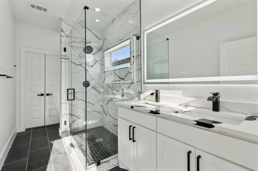 Bathroom featuring vanity, walk in shower, and tile patterned floors