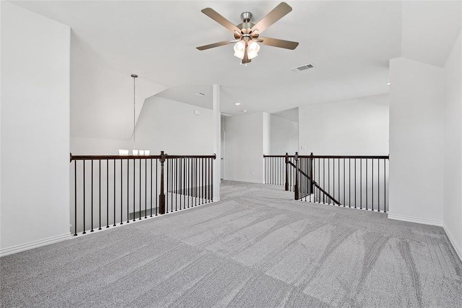 Spare room with vaulted ceiling, light carpet, and ceiling fan