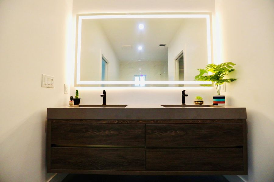 Full bathroom with double vanity and baseboards