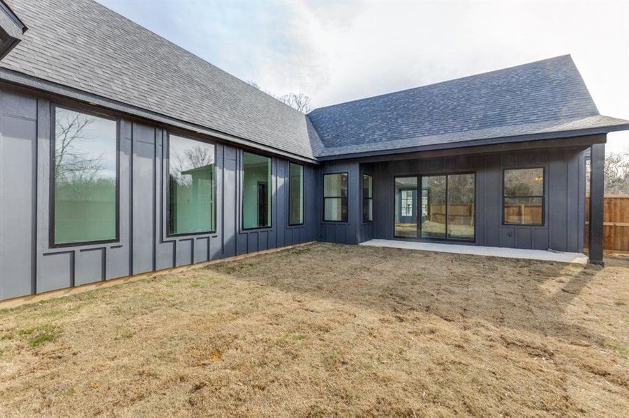 Back of house with a patio and a lawn