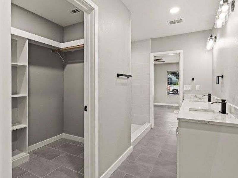 Full bath with a spacious closet, double vanity, and recessed lighting