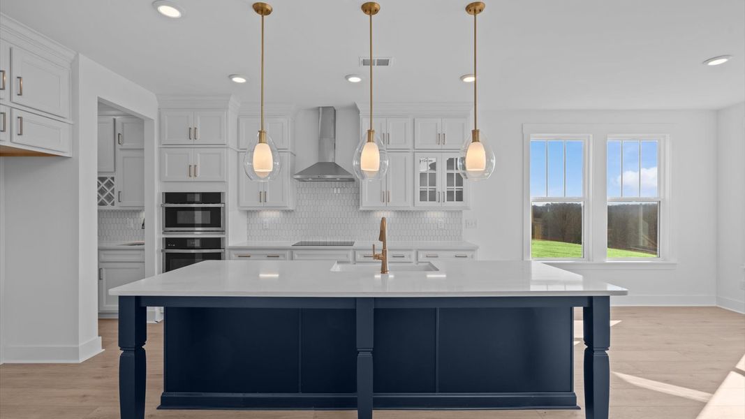 Tasteful design meets functional luxury in this kitchen with a 9-foot island and modern pendant lighting