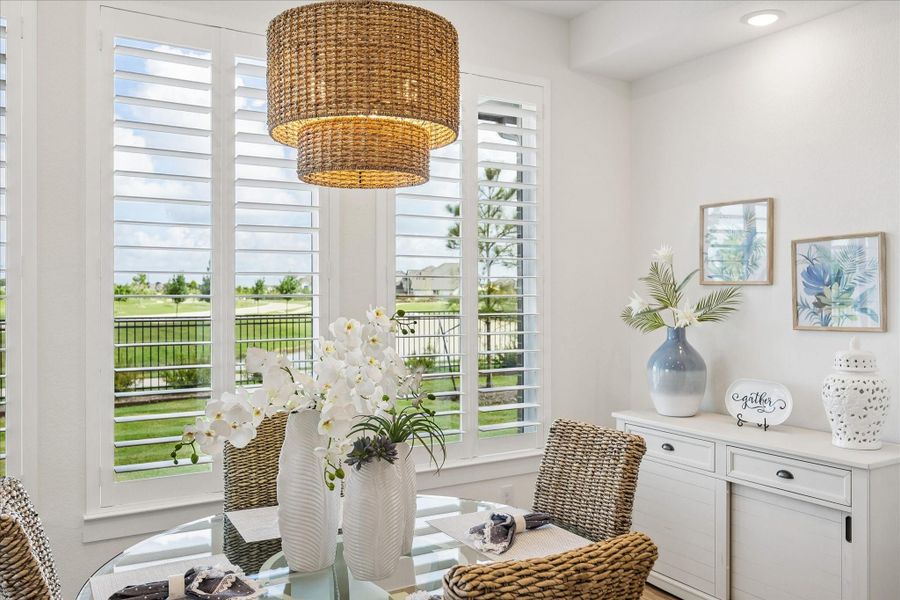 Dining room showcases a beautiful pendant light with scenic views of the water and trails.